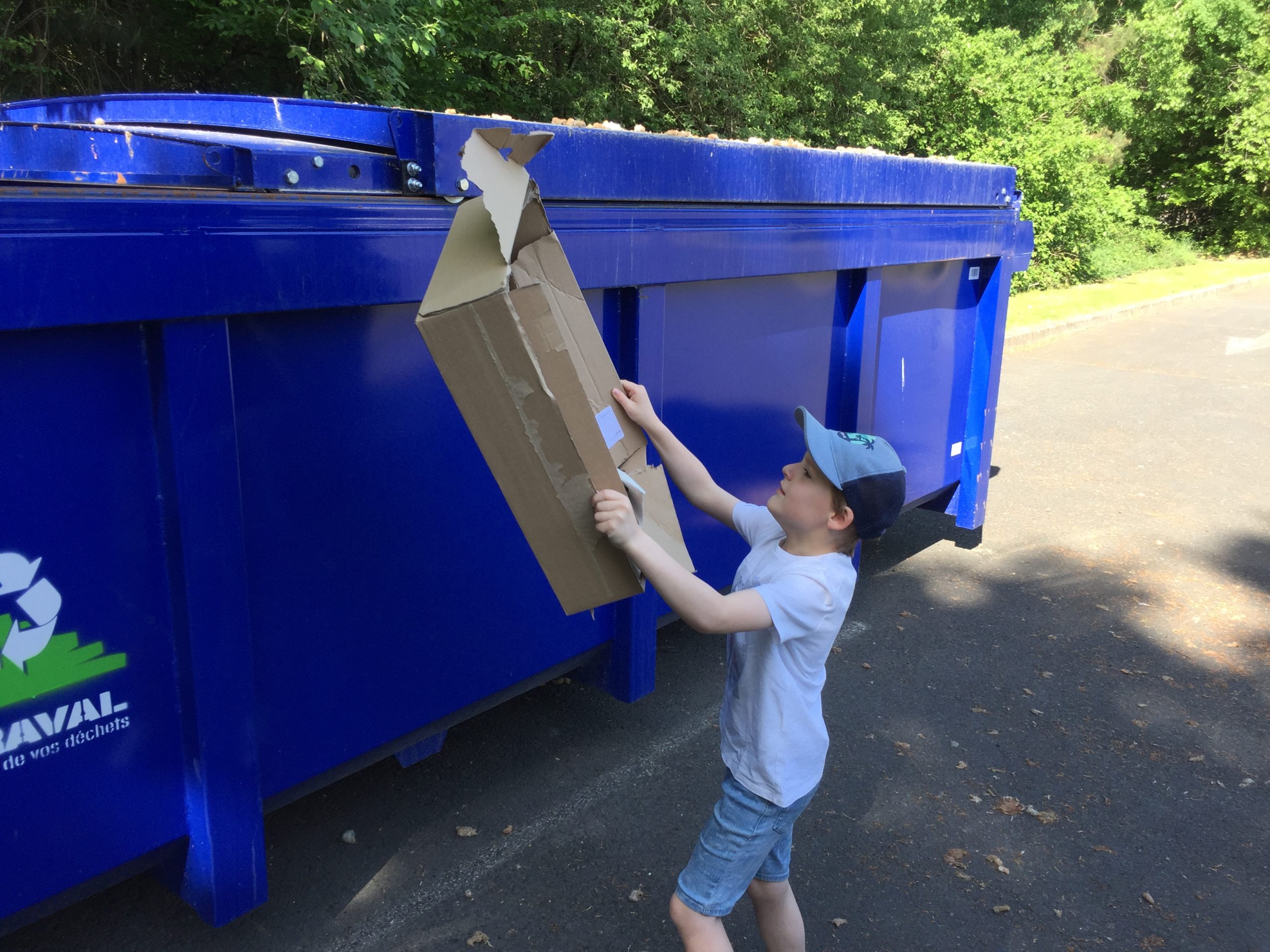 Baptiste profite du retour de la benne bleue pour recycler les vieux cartons de ses parents.
