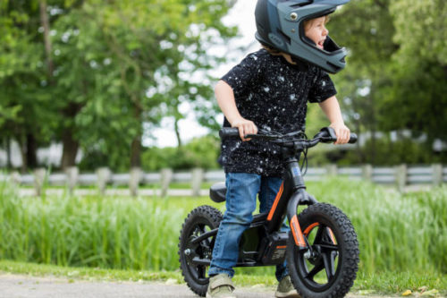 Un enfant faisait de la draisienne, équipé d'un casque