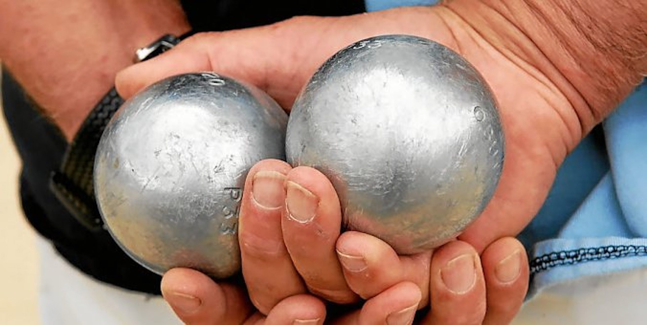 Boules de pétanque dans les mains de son propriétaire.