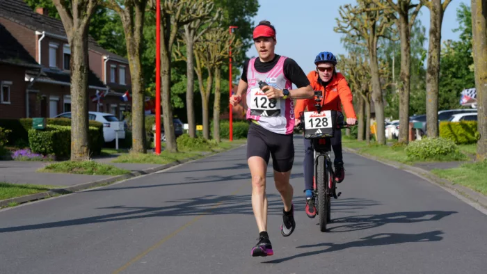 Benjamin Polin en train de courir, accompagné par son frère en vélo, derrière lui.